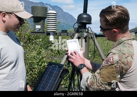 US Air Force Tech. Sgt. J.B. Sexson, der nicht in Auftrag gegebene Offizier der 3rd Operations Support Squadron Airfield Wetteroperation, erklärt Senior Airman Collin Stock, A Survival, Evasion, Resistance, Und Escape-Spezialist, der dem 66. Trainingsgeschwader, Abteilung 1, zur Unterstützung der Operation Colony Glacier an einem abgelegenen Wetterbeobachtungsposten in der Nähe des Colony Glacier, Alaska, zugewiesen wurde, 17. Juni 2021. Die Operation Colony Glacier ist ein Versuch, die Überreste von Dienstmitgliedern und Wracks eines C-124-Flugzeugs, das im November 1952 abstürzte, zu Bergen Stockfoto