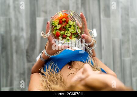 Junge schöne Frau isst Salat für ein gesundes Leben und einen gesunden Körper. Hält ein Maßband, um ihre Taille zu messen. Hochwertige Fotos Stockfoto