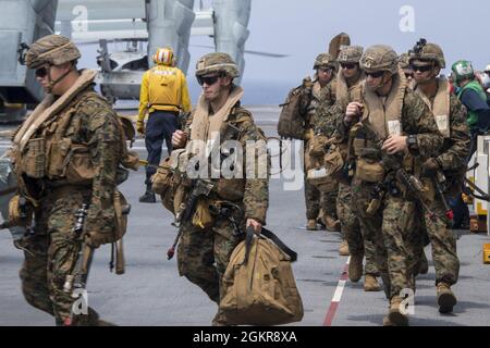 PHILIPPINISCHES MEER (18. Juni 2021) Marineinfanteristen, die der 31. Marine Expeditionary Unit (MEU) zugewiesen sind, bereiten sich darauf vor, einen MV-22B Fischadler, ebenfalls aus der 31. MEU, auf dem Flugdeck des nach vorne eingesetzten amphibischen Angriffsschiffes USS America (LHA 6) zu besteigen. Amerika, das führende Schiff der America Amphibious Ready Group, ist zusammen mit der 31. MEU im Einsatzgebiet der 7. US-Flotte tätig, um die Interoperabilität mit Verbündeten und Partnern zu verbessern und als einsatzbereite Einsatztruppe zur Verteidigung von Frieden und Stabilität in der Indo-Pazifik-Region zu dienen. Stockfoto