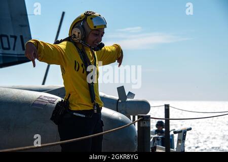 210618-N-OL611-1005 PAZIFISCHER OZEAN (18. Juni 2021) der Mate (Handling) der 3. Klasse von Aviation Boatswain Savannah Kemp, gebürtig aus Pilot Point, Texas, leitet einen Flugzeugaufzug auf dem Flugdeck des Nimitz-Klasse-Flugzeugträgers USS Carl Vinson (CVN 70), 18. Juni 2021. Vinson führt derzeit routinemäßige Seeoperationen in der 3. Flotte der USA durch. Stockfoto