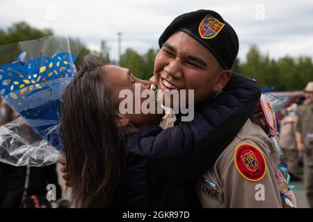 Ein Kadett der Alaska Military Youth Academy umarmt seine Familie nach der Abschlussfeier von AMYA, die am 18. Juni 2021 auf dem Bartlett High School Football Field in Anchorage stattfand. Bei der Zeremonie wurde Alaska LT. Gov. Kevin Meyer als Hauptredner für die 79 Absolventen und ihre Familien. Stockfoto