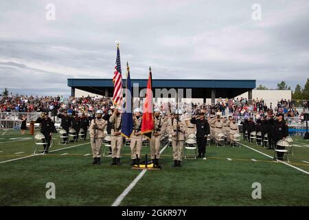 Das Farbschutzteam der Alaska Military Youth Academy präsentiert die Farben, während die Nationalhymne während der Abschlussfeier von AMYA auf dem Bartlett High School Football Field in Anchorage am 18. Juni 2021 spielt. Bei der Zeremonie wurde Alaska LT. Gov. Kevin Meyer als Hauptredner für die 79 Absolventen und ihre Familien. Stockfoto