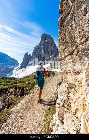 Backpacker Frau mit Wanderstöcken, die den Blick auf Croda Dei Toni vom Weg, Sextner Dolomiten, Südtirol, Italien, Europa genießt Stockfoto