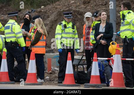 Enfield, Großbritannien. September 2021. Metropolitan Police Officers Arrest beleidigen britische Klimaaktivisten, die an der Kreuzung 25 eine Zufahrtsstraße von der M25 blockiert hatten, als Teil einer Kampagne, die die britische Regierung dazu drängen sollte, wesentliche Gesetzesänderungen vorzunehmen, um die Emissionen zu senken. Die Aktivisten, die am 13. August an Premierminister Boris Johnson schrieben, Fordern, dass die Regierung unverzüglich verspricht, sowohl die vollständige Finanzierung und Isolierung des gesamten sozialen Wohnungsbaus in Großbritannien bis 2025 sicherzustellen als auch innerhalb von vier Monaten einen rechtlich verbindlichen nationalen Plan zur vollständigen Finanzierung und Sicherstellung des vollständigen Wohnungsbaus zu erstellen Stockfoto