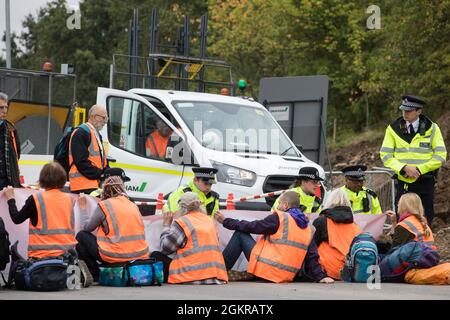 Enfield, Großbritannien. September 2021. Metropolitan Police Officers setzen sich mit britischen Klimaaktivisten in Verbindung, die eine Zufahrtsstraße von der M25 an der Kreuzung 25 blockieren, als Teil einer Kampagne, die die britische Regierung dazu drängen sollte, erhebliche Gesetzesänderungen vorzunehmen, um die Emissionen zu senken. Die Aktivisten, die am 13. August an Premierminister Boris Johnson schrieben, Fordern, dass die Regierung unverzüglich verspricht, sowohl die vollständige Finanzierung und Isolierung des gesamten sozialen Wohnungsbaus in Großbritannien bis 2025 zu gewährleisten als auch innerhalb von vier Monaten einen rechtlich verbindlichen nationalen Plan zur vollständigen Finanzierung und Sicherstellung des gesamten l zu erstellen Stockfoto