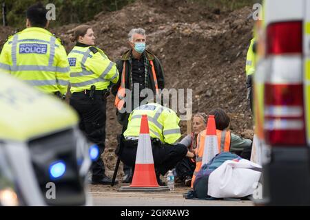 Enfield, Großbritannien. September 2021. Metropolitan Police Officers Arrest beleidigen britische Klimaaktivisten, die an der Kreuzung 25 eine Zufahrtsstraße von der M25 blockiert hatten, als Teil einer Kampagne, die die britische Regierung dazu drängen sollte, wesentliche Gesetzesänderungen vorzunehmen, um die Emissionen zu senken. Die Aktivisten, die am 13. August an Premierminister Boris Johnson schrieben, Fordern, dass die Regierung unverzüglich verspricht, sowohl die vollständige Finanzierung und Isolierung des gesamten sozialen Wohnungsbaus in Großbritannien bis 2025 sicherzustellen als auch innerhalb von vier Monaten einen rechtlich verbindlichen nationalen Plan zur vollständigen Finanzierung und Sicherstellung des vollständigen Wohnungsbaus zu erstellen Stockfoto