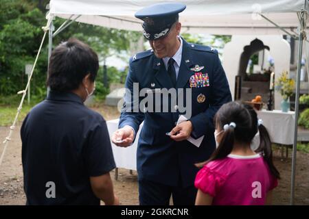 Col. Andrew Campbell, Kommandant des 374. Luftlift-Flügels, Mitte, übergibt Ganchi und Motoki Sugano, den Enkeln des Veranstaltungskoordinators, während einer Gedenkfeier in Shizuoka City, Japan, am 19. Juni 2021 eine Commander-Münze. Campbell schenkte Suganos Enkeln die Münze als Symbol der Freundschaft zwischen Japan und den USA Stockfoto