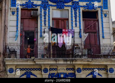 Kleines Kind in der Tür auf dem Balkon mit trocknenden Kleidern, Havanna, Kuba, Westindien, Mittelamerika Stockfoto