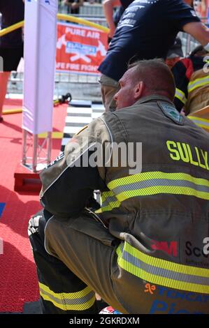 Master-Sgt. Sean Sullivan, Assistant Chief of Training in der 445. Civil Engineer Squadron, erholt sich knieend und blickt auf die offizielle Zeituhr nach seiner letzten Wettbewerbsrunde bei den FireFit Europe Championships am 20. Juni 2021. Die Veranstalter haben den Hindernisparcours in Hannover für die diesjährigen Meisterschaften zusammengestellt. Sullivans letzte Kurslaufzeit betrug 1:29.46, was ihm den ersten Platz in der Altersgruppe über 40 und den achten Platz in der Gesamtwertung einbrachte. Stockfoto