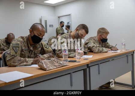 US Army Sgt. Jason Javier (links), ein nicht beauftragter Offizier für Veterinärnahrung bei der 993. Medizinischen Abteilung, 3. Medizinisches Kommando, US Army SPC. Omar Dacosta (Mitte), ein Infanterist mit Company A, 3. Bataillon, 172. Infanterie-Regiment, Task Force Spartan und U.S. Army Sgt. Chad Phillips, ein Infanterist der Bravo Company, des 2. Bataillons, des 136. Infanterie-Regiments und der Task Force Bastards, nimmt im Rahmen des U.S. Army Central 2021 Best Warrior Competition im Camp Arifjan, Kuwait, am 21. Juni 2021 eine schriftliche Prüfung im Education Center ab. Die Konkurrenten mussten einen Essay schreiben und eine 50 beantworten Stockfoto