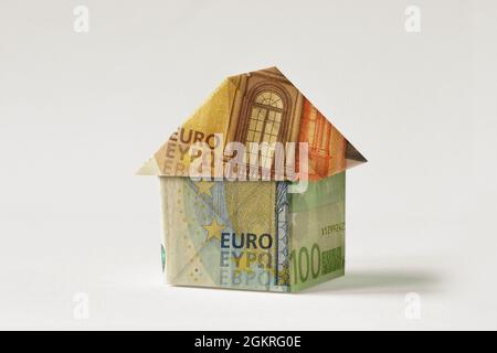 Origami-Haus aus Euro-Banknoten auf weißem Hintergrund - Konzept der Immobilieninvestition, Hypothek, Hausversicherung und Darlehen Stockfoto