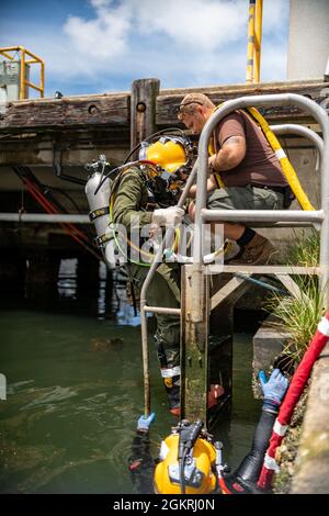 VIRGINIA BEACH, VA. – (21. Juni 2021) Navy Diving 2nd Class Matthew McDorman pflegt den Navy Diving 2nd Class Jared Leestma, während er Tauchoperationen an der Oberfläche durchführt. Beide sind der Mobile Diving Salvage Unit (MDSU) 2, Firma 2-5, zugeordnet. MDSU 2, gegründet von der Joint Expeditionary Base Little Creek - Fort Story, ist eine kampfbereite Expeditionstruppe, die weltweit zur Unterstützung aller Tauch- und Bergungsoperationen eingesetzt werden kann. Stockfoto