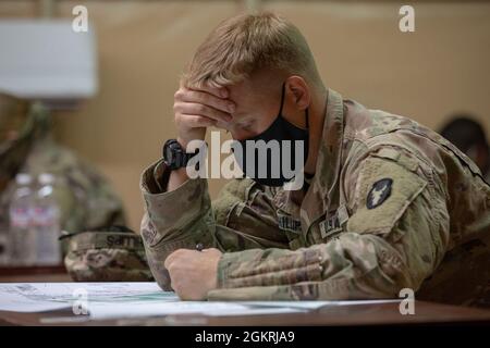 US Army Sgt. Chad Phillips, ein Infanterist der Firma B, 2. Bataillon, 136. Infanterie-Division, Task Force Bastards, nimmt an einer Landnavigationsprüfung im Rahmen des U.S. Army Central 2021 Best Warrior Competition im Camp Arifjan, Kuwait, 22. Juni 2021 Teil. Die Konkurrenz musste Karten lesen, Punkte zeichnen und einen Kompass verwenden, um einen Azimut zu schießen. Stockfoto