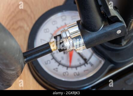 Nahaufnahme einer Pumpe mit Manometer, das Luft in ein Ventil des Innenrohrs bläst Stockfoto