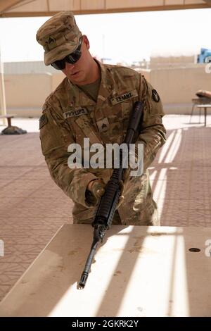 Sgt. Chad Phillips, ein Infanterist mit Company B., 2nd Combined Arms Battalion, 136. Infanterie-Regiment führt während eines Waffenevents für den U.S. Army Central 2021 Best Warrior Competition im Camp Arifjan, Kuwait, 22. Juni 2021 eine Funktionsprüfung an einem M4-Karabinergewehr durch. Die Teilnehmer wurden im Rahmen der Veranstaltung mit der Demontage, dem Zusammenbau und der Durchführung einer Funktionsprüfung verschiedener Waffen beauftragt. Stockfoto