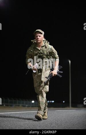 US Army Sgt. Chad Phillips, ein Infanterist mit der Firma B, dem 2. Kombinierten Waffen-Bataillon, dem 136. Infanterie-Regiment, marschiert 8 Meilen während des U.S. Army Central 2021 Best Warrior Competition im Camp Arifjan, Kuwait, 22. Juni 2021. Die Teilnehmer hatten während der gesamten Dauer des Rocks einen 35-Pfund-Ruck-Sack und eine Waffe bei sich. Stockfoto