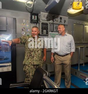 KINGS BAY, Georgia, (22. Juni 2021) LT. Cmdr. Jeremy Lord, Executive Officer der Trident Training Facility, zeigt während einer Tour Todd Schafer, amtierender stellvertretender Sekretär der Marine für Energie, Installationen und Umwelt, den Tauchgang- und Fahrtrainer des U-Bootes. Während des Besuchs der Naval Submarine Base Kings Bay besichtigte Schafer auch das U-Boot USS Tennessee (SSBN 734) der Ohio-Klasse mit ballistischen Raketen und das Basisgehäuse. Stockfoto