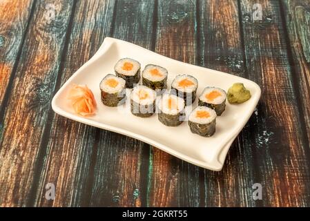 Japanisches Reis Sushi Maki Roll mit norwegischem Lachs und Nori Algen mit Wasabi und Ginseng Stockfoto