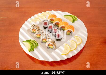 Gemischtes Sushi-Tablett mit Uramaki california Roll, Uramaki mit einer Scheibe norwegischen Lachs und Maki mit rotem Thunfisch, japanischem Reis, reifer Avocado und NOR Stockfoto