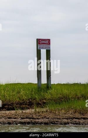 Ein gut sichtbarer Schild warnt die Menschen vor den potenziellen Gefahren auf Browns Island, North Carolina, 23. Juni 2021. Browns Island ist für alle Besucher nicht zugänglich, es sei denn, es ist für Trainingsübungen zugelassen. Militärpersonal, das die Insel erreicht, muss aufgrund der extremen Gefahren, die mit einem hochgefährlichen Aufprallgebiet verbunden sind, von EOD-Mitarbeitern begleitet werden. Stockfoto