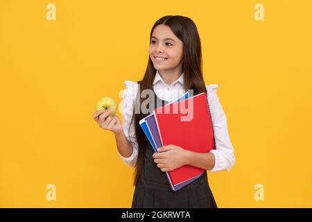 Willkommen zurück in der Schule. Glückliches Kind lächelt mit Apfel und Büchern. Zurück zur Schule. Back-to-School Stockfoto