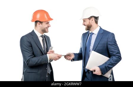 Investition in Architekturprojekt. Männer Geschäftsleute in Hardhat mit Geld und Laptop. Stockfoto