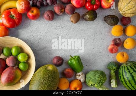 Obst und Gemüse der Saison auf weißem Putz. Grüner Brokkoli, Wassermelone und Melonen, grüne Limetten, afrikanische Mangos, Pfirsiche und Nektarinen, Sehr klar Stockfoto