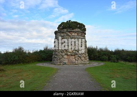 Kreisförmiges Steindenkmal in Culloden Moor, dem Ort einer berühmten Schlacht und einer beliebten Touristenattraktion. Blauer Himmel, Wolken, keine Menschen. Stockfoto