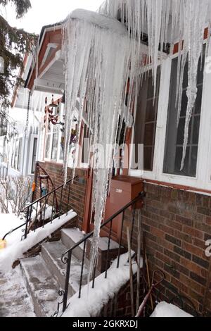 Große Eiszapfen an der Eingangstür, die vom Dach hängen. St. Paul Minnesota, USA Stockfoto