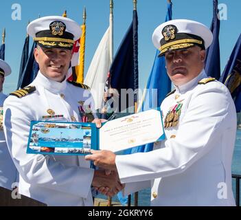 Bef. Don Emerson, scheidender Kommandant, Naval Magazine Indian Island, links, erhält eine Verdienstmedaille von Rear ADM. Brad Collins, Kommandant der Navy Region Northwest, während einer Befehlswechselzeremonie bei NMII in Port Hadlock, Washington, 24. Juni 2021. Während der Zeremonie, Cmdr. Andrew Crouse entließ Emerson als Kommandanten von NMII. Stockfoto