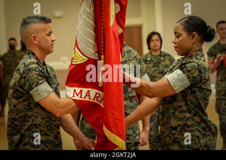 US Marine Corps LT. Col. Jeremy M. Nelson, links, ankommender Kommandooffizier, Personal Administration School (PAS), Marine Corps Combat Service Support Schools (MCCSSS), erhält die Einheitsfarben von LT. Col. Nicole M. Bohannon, ausscheidender Kommandooffizier, PAS, MCCSSS, während der PAS-Befehlswechsel-Zeremonie in Camp Lejeune, N.C., 24. Juni 2021. Die Befehlswechselzeremonie stellt die offizielle Übergabe der Autorität vom scheidenden Kommandanten an den ankommenden Kommandanten dar. Stockfoto