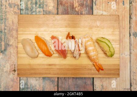 Beliebtes japanisches Bambusblech mit Garnelennigiri-Stücken mit Reis, Butterfisch, norwegischem Lachs, rotem Thun, Aal und Avocado. Stockfoto