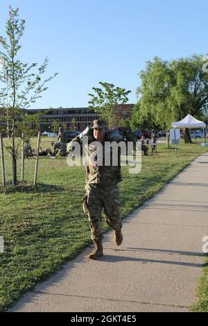 FORT GEORGE G. MEADE, MD. – SPC. Ammon Bausman, Eine Kompanie, 742. Militärgeheimdienstbataillon, trägt 20-Pfund-Sandsäcke um das Paradefeld bei einem Ereignis, das die Organisatoren des „2021 Tribute to the Fallen“ namens „Weight of the Fallen“ tragen, um das Gewicht auszudrücken, das alle Dienstmitglieder nach dem Verlust ihrer gefallenen Kameraden tragen. Stockfoto