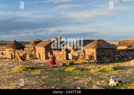 PUNO, PERU - 14. MAI 2015: Kleine Siedlung in der Nähe von Puno, Peru. Alte Frauen mit Lamas anwesend. Stockfoto