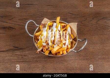 Portion Chips mit Frischkäse-Cheddar-Sauce und gebratenem Speck und Hühnchen-Stücken Stockfoto