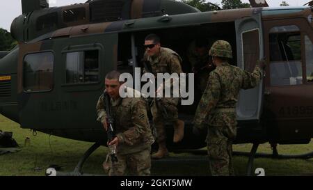 Soldaten der US-Armee, die dem 1. Bataillon, dem 28. Infanterie-Regiment, der 3. Infanterie-Division, zugewiesen sind, verlassen während des bilateralen Trainings auf dem Aibano Training Area, Japan, 26. Juni 2021, einen Hubschrauber der japanischen Selbstverteidigungskräfte im Rahmen der Übung Orient Shield 21-2. Orient Shield ist die größte bilaterale Außendienstschulung der US-Armee und der JGSDF, die an verschiedenen Standorten in ganz Japan durchgeführt wird, um die Interoperabilität zu verbessern und den Multi-Domain- und Cross-Domain-Betrieb zu testen und zu verfeinern. Stockfoto
