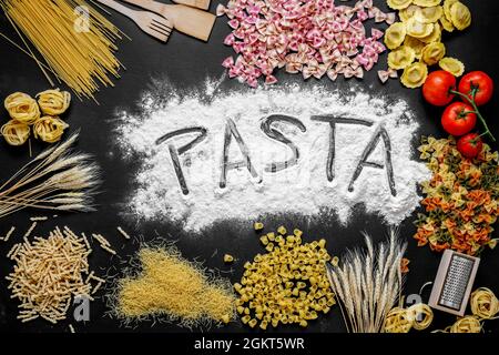 Zusammensetzung mit verschiedenen Arten von italienischen Pasta, mit Mehl und Weizen und das Wort Pasta auf schwarzem Hintergrund geschrieben Stockfoto