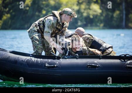 Mitglieder des 303. Kavallerieregiments der 1. Staffel holen am Freitag, den 25. Juni 2021, während des helo-Gewehrtrainings am American Lake außerhalb der Joint Base Lewis-McChord, Washington, Soldaten aus dem Wasser zurück. Stockfoto