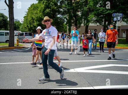 YOKOSUKA, Japan (26. Juni 2021) – Capt. Rich Jarrett, Commander, Fleet Activities Yokosuka (CFAY), winkt beim ersten jährlichen Pride March and Festival in CFAY den Zuschauern zu, als Anerkennung für LGBTQ-Mitglieder, die in den Streitkräften dienen. Die Feier wurde von jungen Matrosen des US Naval Hospital Yokosuka und des multikulturellen Komitees der CFAY geleitet und beinhaltete einen bunten marsch, Unterstützungsstände, Spiele, Musik, Essen, Und Erfrischungen im Kosano Park, an Bord von CFAY. Seit mehr als 75 Jahren bietet, pflegt und betreibt CFAY Basiseinrichtungen und -Dienstleistungen im bereich support Stockfoto