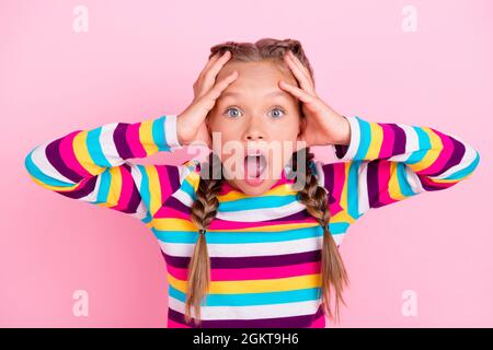 Foto von verrückten verrückt beunruhigt kleine Dame Hände Kopf brüllen offenen Mund tragen gestreiftes Hemd isoliert rosa Farbe Hintergrund Stockfoto