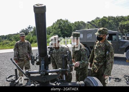 Soldaten der US-Armee, die dem 1. Bataillon, dem 28. Infanterie-Regiment, der 3. Infanterie-Division, zugewiesen sind, schauen durch die Optik eines 120-mm-Mörsers der japanischen Selbstverteidigungskräfte, während JGSDF-Mitglieder auf dem Aibano Training Area, Japan, am 28. Juni 2021, im Rahmen der Übung Orient Shield, die Ausrüstung beobachten. Orient Shield ist die größte bilaterale Außendienstschulung der US-Armee und der JGSDF, die an verschiedenen Standorten in ganz Japan durchgeführt wird, um die Interoperabilität zu verbessern und den Multi-Domain- und Cross-Domain-Betrieb zu testen und zu verfeinern. Stockfoto