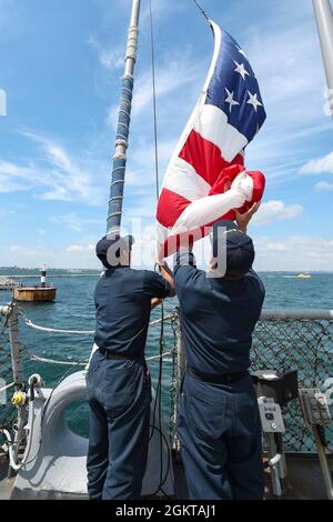 ODESSA, Ukraine (27. Juni 2021) Fire Controlman (Aegis) 3rd Class Arthur Cataag, Left, und Fire Controlman (Aegis) 3rd Class Jaime Culver, zugewiesen an den Arleigh Burke-Klasse Lenkflugkörper-Zerstörer USS Ross (DDG 71), heben den nationalen Ensign an, während das Schiff am 27. Juni 2021 in Odessa, Ukraine, in den Hafen einfährt. Ross, der im spanischen Rota stationiert ist, ist auf Patrouille im Einsatzgebiet der Sechsten Flotte der USA, um regionale Verbündete und Partner sowie nationale Sicherheitsinteressen der USA in Europa und Afrika zu unterstützen. Stockfoto