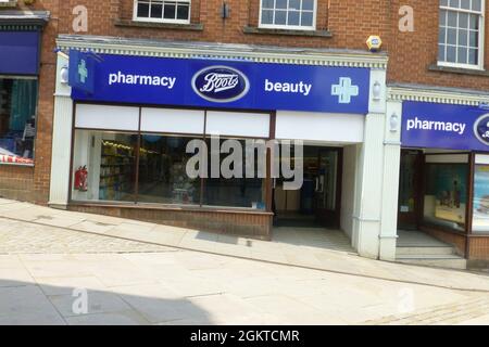 Boots Pharmacy und Beauty Ross on Wye UK Shop Chemiker Apotheke Vordertür Feuerlöscher Alarm Glockenschild Glaspflaster Straße Pfad Stockfoto
