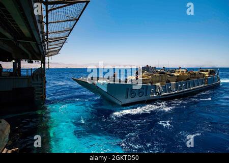 210628-N-NQ285-1107 ROTES MEER (28. Juni 2021) Landing Craft, Utility (LCU) 1661, zugewiesen an Assault Craft Unit (ACU) 2, tritt während des LCU-Betriebs im Roten Meer am 28. Juni in das Brunnendeck des Docklandungsschiffes USS Carter Hall (LSD 50) ein. Carter Hall wird im Einsatzgebiet der 5. US-Flotte eingesetzt, um Marineinteraktionen zu unterstützen, um die maritime Stabilität und Sicherheit in der Zentralregion zu gewährleisten und das Mittelmeer und den Pazifik durch den westlichen Indischen Ozean und drei strategische Engpässe zu verbinden. Stockfoto