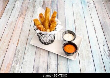 Neo Rezept für Patatas Bravas mit Schalen von Saucen als Tapas im spanischen Restaurant auf Holztisch dienen Stockfoto