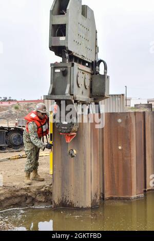 210629-N-TO226-1164 PORT HUENEME, Kalifornien (23. Juni 2021) der Ausrüstungsbetreiber der 3. Klasse, David James, der dem U.S. Naval Mobile Construction Bataillon 3 zugewiesen wurde, überprüft, ob der Blattstapel während der Ausbildung zur Reparatur von Hafenschäden an Bord des Marinestützpunktes Ventura County, Port Hueneme, plumpt. Seabees sind die Expeditions- und Bauexperten des Marineservice. Sie stellen aufgabengerechte, anpassungsfähige und kampfbereite Konstruktions- und Konstruktionskräfte bereit, die zur Unterstützung der Ziele der Marine weltweit eingesetzt werden. Stockfoto