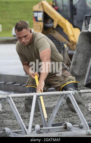 Senior Airman Kendall Allison, 819. RED HORSE Squadron Strukturgeselle, baut im Rahmen eines Bauprojekts zur Erweiterung eines Fluglinienvorfeldes am 30. Juni 2021 auf dem Yokota Air Base, Japan, feuchten Beton. Das Bauprojekt erfordert, dass Airmen, die den 823., 819. Und 820. RED HORSE Squadrons zugewiesen sind, etwa 7,300 Kubikmeter Beton gießen und 650 Tonnen Asphalt pflastern, um die Parkkapazitäten der Flugzeuge auf dem Yokota Air Base zu erhöhen. Die Erweiterung des Vorfeldes ist die erste in einer etwa vierjährigen Phase der Bauarbeiten zur Verbesserung der Luftbrücke des Yokota Air Base Stockfoto