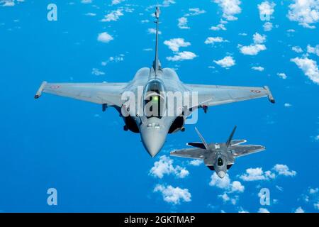 Ein Hawaii Air National Guard F-22 Raptor fliegt in Formation mit einem F3-R Rafale der französischen Luft- und Raumfahrtstreitkräfte am 30. Juni 2021 in der Nähe von Oahu, Hawaii. Vom 27. Juni bis 5. Juli wurden drei französische Luftstreitkräfte Rafales, zwei A400M Atlas, ein A330 Phenix, Und etwa 170 Mitarbeiter der französischen Luft- und Raumfahrtstreitkräfte besuchten die Joint Base Pearl Harbor-Hickam, um sich an Luftintegrationsoperationen für die Übung Wakea zu arbeiten - eine Demonstration der Beziehungen zwischen den USA und Frankreich im Verantwortungsbereich des Indo-pazifik-raums. Während des Wakea tauschten Experten beider Nationen bewährte Verfahren für Flugbetrieb, Schulung und aus Stockfoto