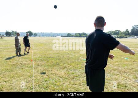 Capt. Andrew Bartlett, ein Infanterieoffizier, der dem 6. Rekrutierungs- und Retentionsbataillon der Connecticut Army National Guard zugewiesen wurde, wirft während des stehenden Kraftwerftests des Army Combat Fitness Tests in Camp Net, Niantic, Connecticut, 30. Juni 2021 einen 10 Pfund schweren Medizinball. Soldaten erhalten zwei Versuche, den Medizinball mindestens viereinhalb Meter zu werfen. Stockfoto