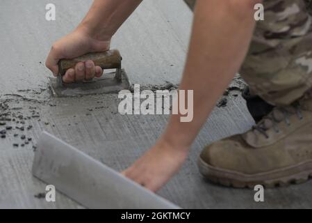 Personal Sgt. Andrew Vandell, 823. RED HORSE Squadron Strukturbauarbeiter, baut im Rahmen eines Bauprojekts zur Erweiterung eines Fluglineprons am 30. Juni 2021 auf dem Yokota Air Base, Japan, feuchten Beton. Flugleute, die den 823., 819. Und 820. RED HORSE Squadrons zugewiesen wurden, kombinierten ihre Bemühungen, die Parkkapazitäten für Flugzeuge zu erhöhen. Die Erweiterung des Vorfeldes ist die erste in einer etwa vierjährigen Phase der Bauarbeiten zur Verbesserung der Luftwaffenmission des Flugstützpunkts Yokota und das erste 800. PROJEKT DER RED HORSE Group im US-amerikanischen Indo-Pazifik-Raum. Stockfoto